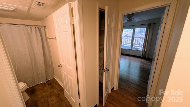 105 Toxaway Views Dr Unit 402, Lake Toxaway, NC 28747 - full bathroom featuring wood finished floors, toilet, a ceiling fan, a shower with curtain, and a paneled ceiling