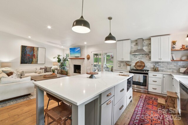 5 Lowry Ln, Weaverville, NC 28787 - kitchen with stainless steel appliances, wall chimney range hood, open shelves, open floor plan, and light countertops