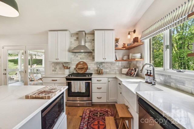 5 Lowry Ln, Weaverville, NC 28787 - kitchen with wall chimney range hood, stainless steel appliances, plenty of natural light, and light wood-type flooring