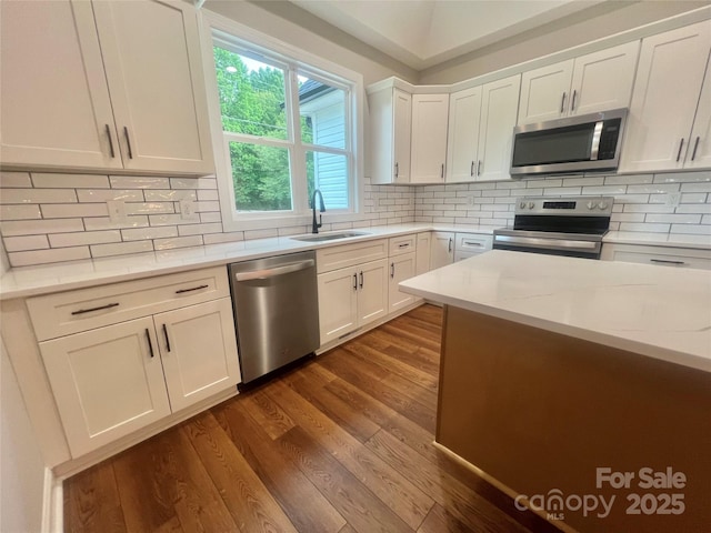 1143 Journey Ln, Salisbury, NC 28146 - kitchen featuring stainless steel appliances, a sink, dark wood-type flooring, white cabinets, and backsplash