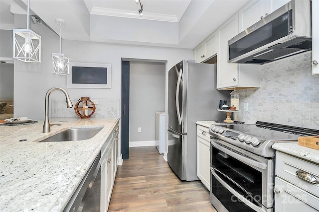 300 W 5th St Unit 003, Charlotte, NC 28202 - kitchen featuring appliances with stainless steel finishes, crown molding, a raised ceiling, white cabinets, and wood finished floors