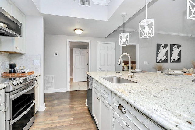 300 W 5th St Unit 003, Charlotte, NC 28202 - kitchen featuring stainless steel appliances, extractor fan, dark wood-type flooring, light stone countertops, and white cabinetry