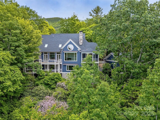 251 Toxaway Ct, Lake Toxaway, NC 28747 - view of front of home with a chimney, roof with shingles, and a balcony