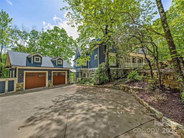 251 Toxaway Ct, Lake Toxaway, NC 28747 - view of front of property featuring stone siding, driveway, an outdoor structure, and roof with shingles
