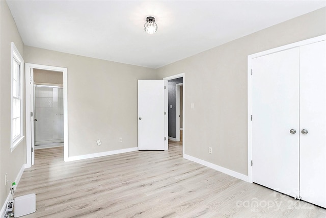 7118 April Ridge Ln, Charlotte, NC 28215 - unfurnished bedroom with light wood-style flooring, baseboards, a closet, and ensuite bath