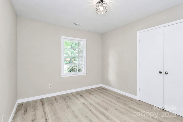 7118 April Ridge Ln, Charlotte, NC 28215 - unfurnished bedroom featuring light wood finished floors, baseboards, and a closet