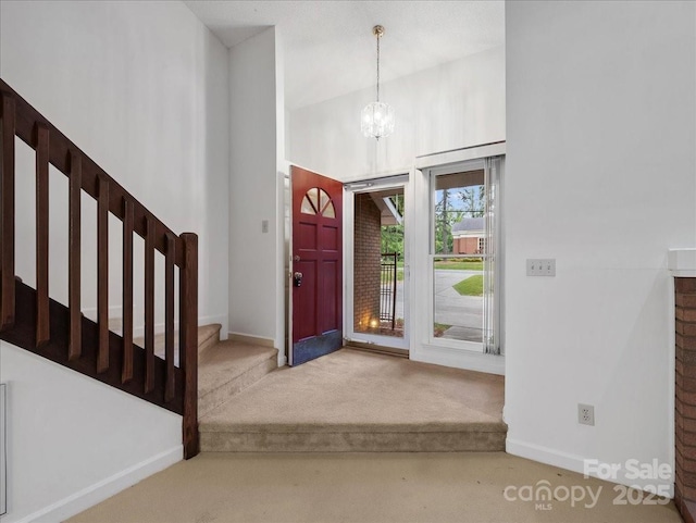 3327 Archdale Dr, Charlotte, NC 28210 - carpeted entryway with a chandelier, stairs, baseboards, and a towering ceiling