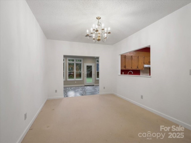 3327 Archdale Dr, Charlotte, NC 28210 - carpeted spare room featuring a chandelier, baseboards, and a textured ceiling