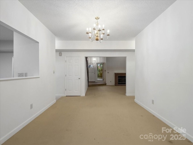 3327 Archdale Dr, Charlotte, NC 28210 - unfurnished living room with a chandelier, baseboards, carpet flooring, and a textured ceiling
