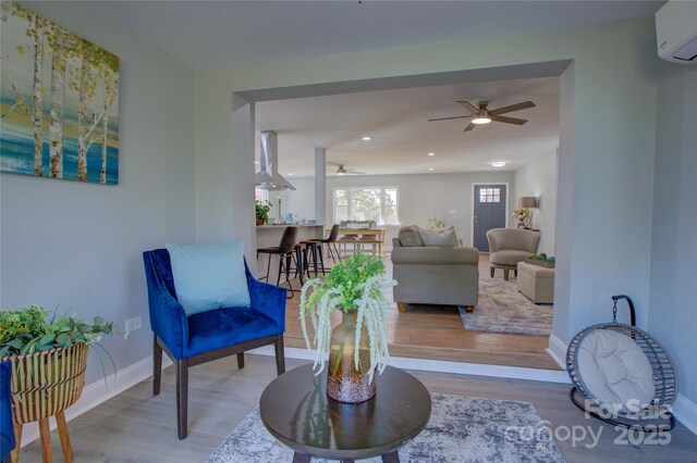 8607 Larchmont Cir, Charlotte, NC 28214 - living room featuring a ceiling fan, a wall mounted air conditioner, wood finished floors, baseboards, and recessed lighting