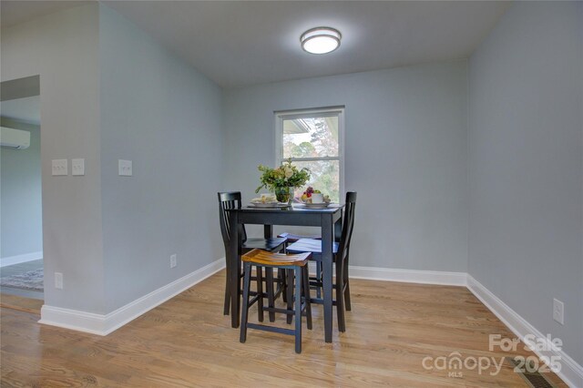 8607 Larchmont Cir, Charlotte, NC 28214 - dining area featuring a wall mounted AC, light wood finished floors, and baseboards