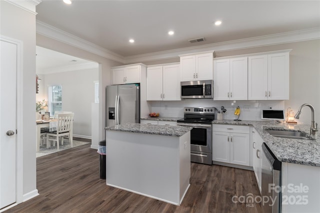 148 Kerri Dawn Ln, Locust, NC 28097 - kitchen with appliances with stainless steel finishes, a sink, white cabinetry, dark wood-style flooring, and crown molding