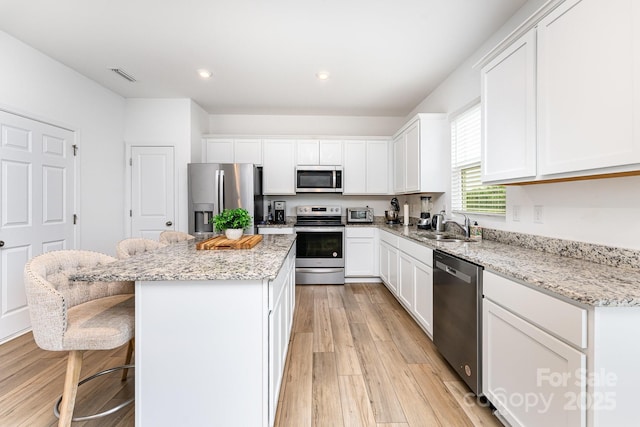 3077 Light Ridge Ct SW, Concord, NC 28027 - kitchen featuring stainless steel appliances, a center island, a sink, white cabinets, and recessed lighting