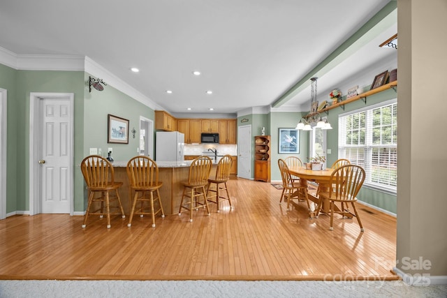 6533 Derby Ln NW, Concord, NC 28027 - dining space with light wood-style floors, baseboards, recessed lighting, and crown molding