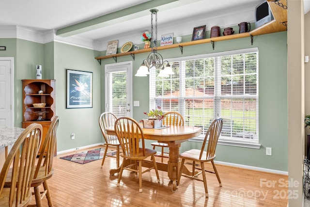 6533 Derby Ln NW, Concord, NC 28027 - dining area with a chandelier, light wood-style flooring, baseboards, and crown molding