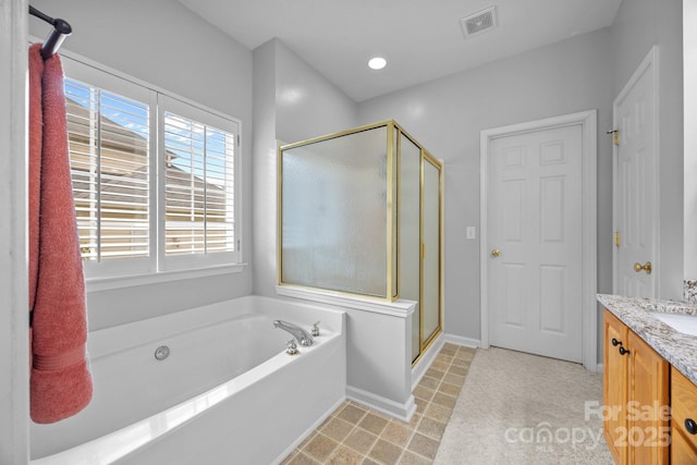 6533 Derby Ln NW, Concord, NC 28027 - bathroom featuring vanity, a stall shower, a garden tub, and baseboards