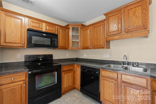 116 Dean Rd, Anderson, SC 29625 - kitchen featuring black appliances, a sink, dark countertops, brown cabinets, and a textured ceiling
