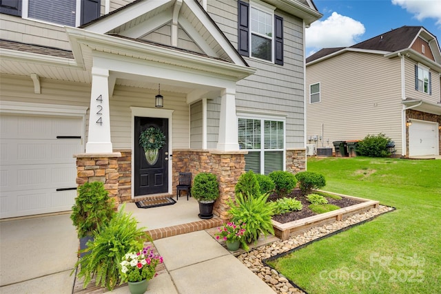424 Castlebury Ct, Clover, SC 29710 - view of exterior entry featuring stone siding, a lawn, covered porch, and an attached garage