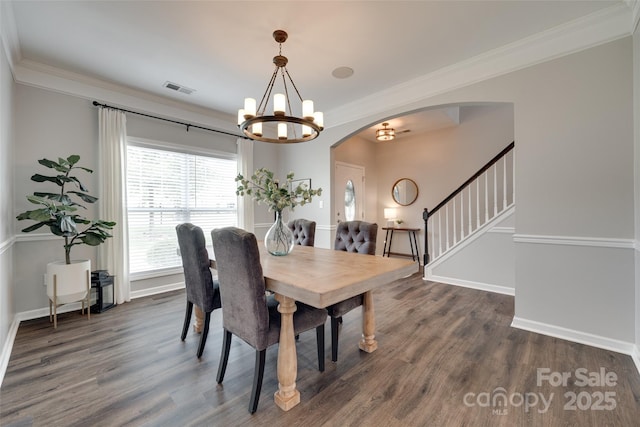 424 Castlebury Ct, Clover, SC 29710 - dining room featuring arched walkways, dark wood-style flooring, a chandelier, crown molding, and baseboards