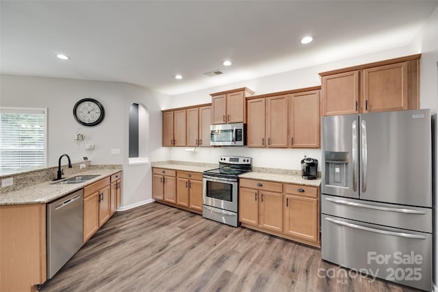 424 Castlebury Ct, Clover, SC 29710 - kitchen with appliances with stainless steel finishes, a sink, arched walkways, a peninsula, and wood finished floors