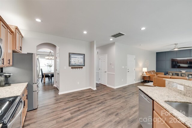 424 Castlebury Ct, Clover, SC 29710 - kitchen featuring appliances with stainless steel finishes, wood finished floors, light stone counters, arched walkways, and a ceiling fan