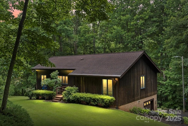 460 27th Avenue Cir NW, Hickory, NC 28601 - back of house with roof with shingles, a yard, an attached garage, and a wooded view