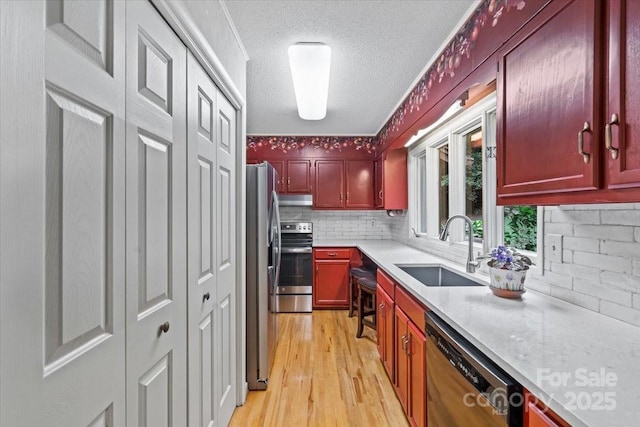 460 27th Avenue Cir NW, Hickory, NC 28601 - kitchen featuring a sink, stainless steel appliances, reddish brown cabinets, light wood finished floors, and decorative backsplash