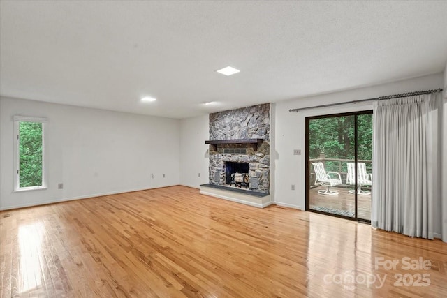 460 27th Avenue Cir NW, Hickory, NC 28601 - unfurnished living room with wood finished floors, a stone fireplace, and baseboards
