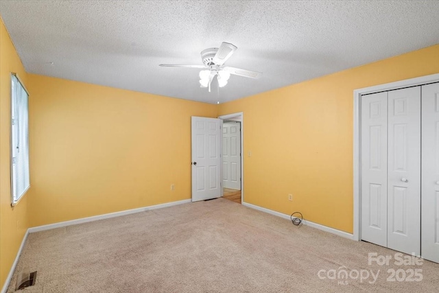 460 27th Avenue Cir NW, Hickory, NC 28601 - unfurnished bedroom with light colored carpet, baseboards, a closet, a textured ceiling, and ceiling fan