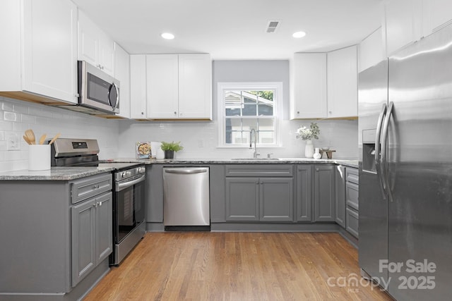 4838 Keats Ave, Charlotte, NC 28212 - kitchen with stainless steel appliances, gray cabinetry, light stone countertops, backsplash, and recessed lighting