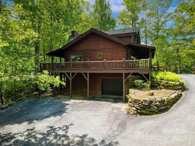 76 Isuhdavga Ct, Brevard, NC 28712 - log-style house with a deck, log siding, asphalt driveway, and a garage