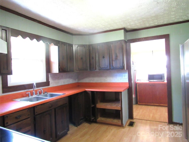 85 Oshea Ln, Waynesville, NC 28786 - kitchen with a sink, crown molding, light wood-type flooring, stainless steel microwave, and dark brown cabinetry