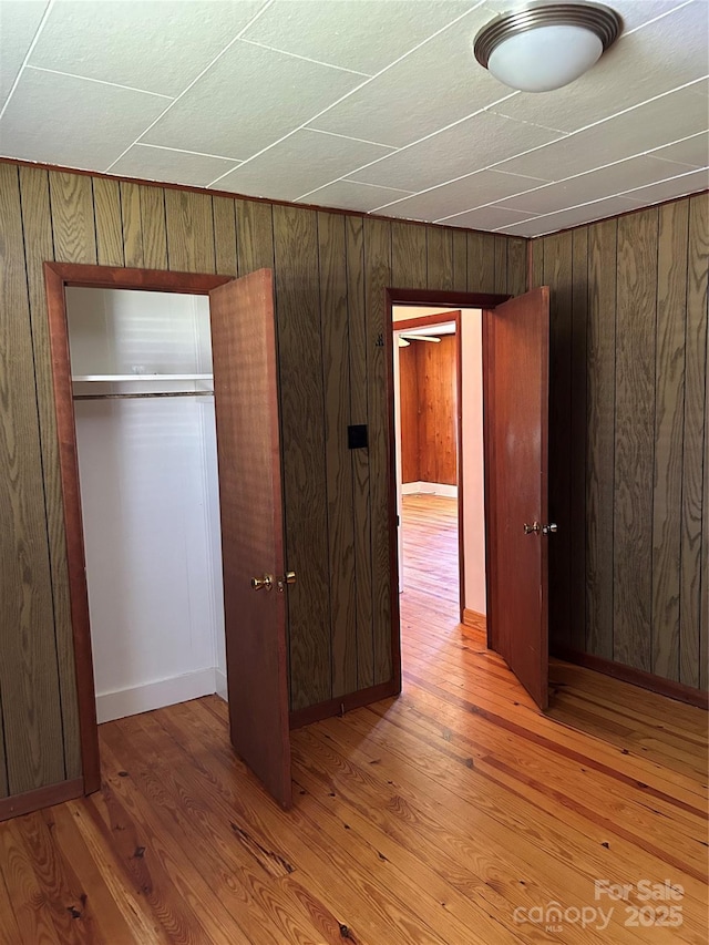85 Oshea Ln, Waynesville, NC 28786 - unfurnished bedroom with wooden walls, a closet, and light wood-style flooring