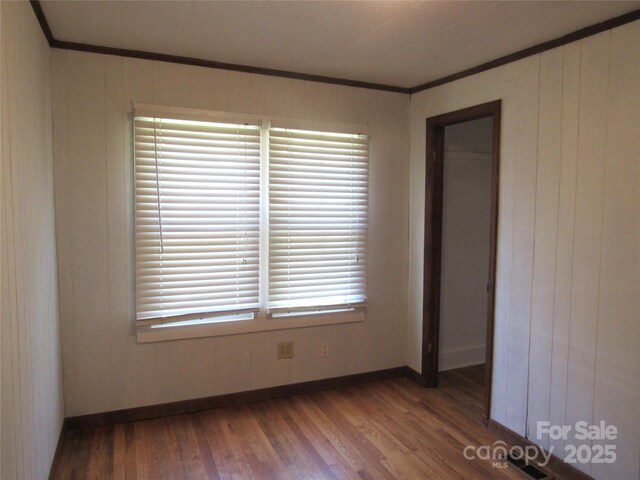 85 Oshea Ln, Waynesville, NC 28786 - empty room with crown molding, baseboards, wood finished floors, and wooden walls