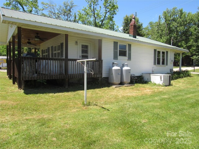 85 Oshea Ln, Waynesville, NC 28786 - view of front of home with ceiling fan, a deck, a front yard, metal roof, and a chimney