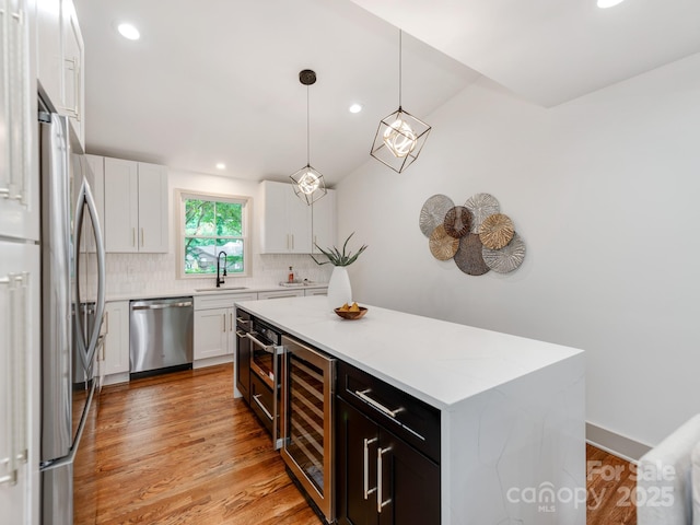 2114 Thurmond Pl, Charlotte, NC 28205 - kitchen with stainless steel appliances, beverage cooler, decorative backsplash, a sink, and white cabinetry