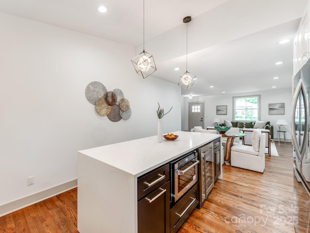 2114 Thurmond Pl, Charlotte, NC 28205 - kitchen featuring light wood-type flooring, wine cooler, recessed lighting, pendant lighting, and light countertops