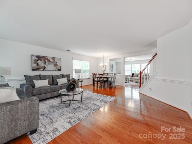 6532 Prosperity Commons Dr, Charlotte, NC 28269 - living room featuring a chandelier, light wood-type flooring, stairway, and baseboards