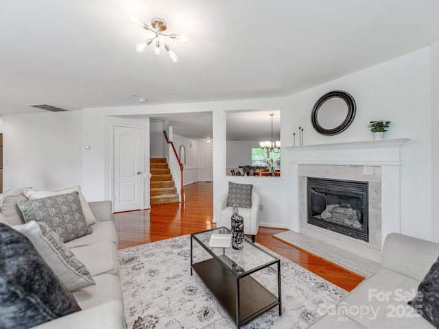 6532 Prosperity Commons Dr, Charlotte, NC 28269 - living area with stairs, wood finished floors, a chandelier, and a high end fireplace