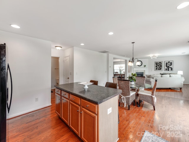 6532 Prosperity Commons Dr, Charlotte, NC 28269 - kitchen with freestanding refrigerator, dark countertops, light wood finished floors, a kitchen island, and open floor plan