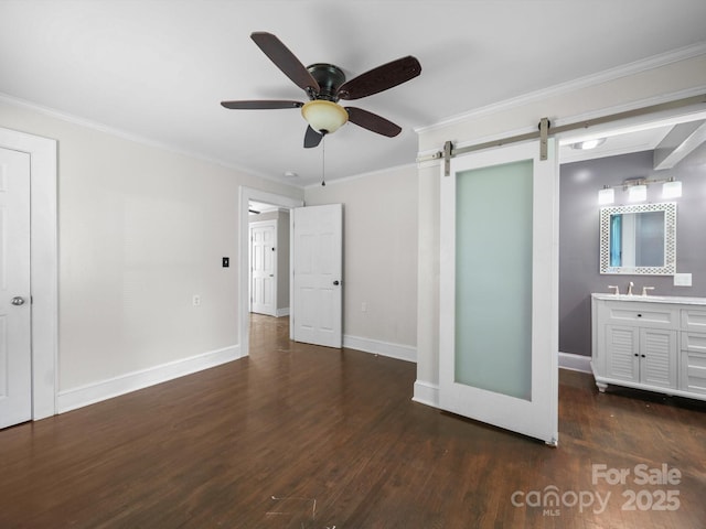 322 Peachtree St, Albemarle, NC 28001 - unfurnished bedroom featuring a barn door, wood finished floors, ornamental molding, and a ceiling fan