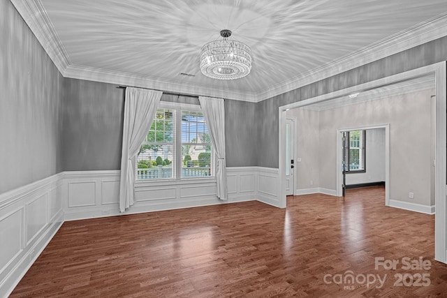 16909 Red Cow Rd, Charlotte, NC 28277 - unfurnished room with a chandelier, crown molding, wainscoting, and wood finished floors