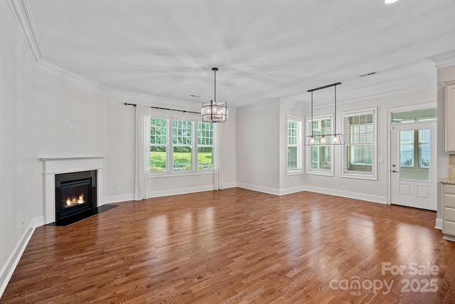 16909 Red Cow Rd, Charlotte, NC 28277 - unfurnished living room featuring a chandelier, a fireplace with flush hearth, crown molding, and wood finished floors