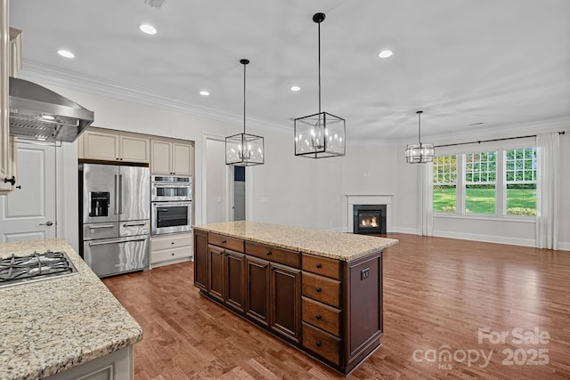 16909 Red Cow Rd, Charlotte, NC 28277 - kitchen featuring stainless steel appliances, wall chimney exhaust hood, dark wood-style floors, a center island, and crown molding