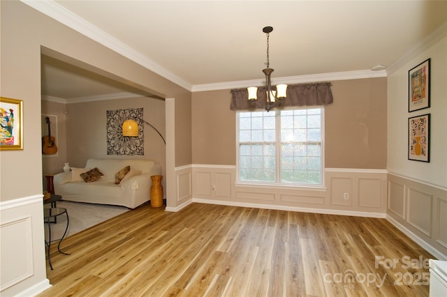 4001 Brook Valley Run, Monroe, NC 28110 - unfurnished dining area with light wood-style floors, a chandelier, ornamental molding, wainscoting, and a decorative wall
