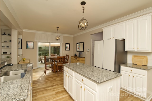 4001 Brook Valley Run, Monroe, NC 28110 - kitchen with freestanding refrigerator, a sink, a center island, ornamental molding, and light wood-style floors