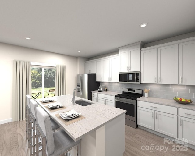 406 Luna Ln, Shelby, NC 28152 - kitchen with stainless steel appliances, an island with sink, tasteful backsplash, light wood finished floors, and recessed lighting