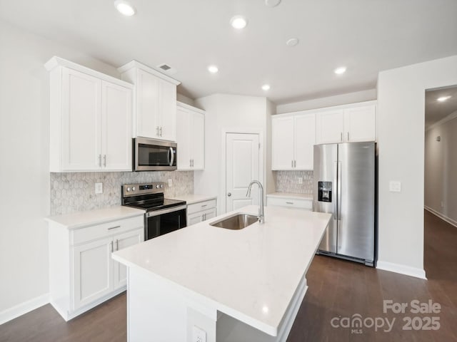 2119 Rolling Hills Ct, Stanley, NC 28164 - kitchen with appliances with stainless steel finishes, decorative backsplash, white cabinetry, a kitchen island with sink, and recessed lighting