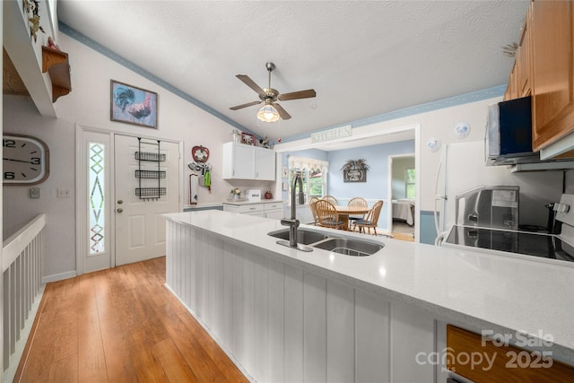 131 Apple Blossom Ln, Maggie Valley, NC 28751 - kitchen with vaulted ceiling, a sink, a ceiling fan, a textured ceiling, and light wood-style flooring