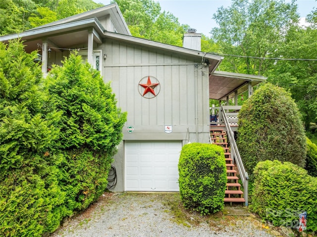 131 Apple Blossom Ln, Maggie Valley, NC 28751 - view of home's exterior with stairs, a chimney, a garage, and gravel driveway